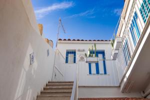 una escalera que conduce a un edificio blanco con puertas azules en SyracuseApartments IL PASUBIO di SIRACUSA Stupendo appartamento vicino ad ORTIGIA a 200m dal MARE, en Siracusa