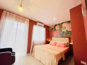 1 dormitorio con 1 cama con un mural de flores en la pared en Townhouse with game area and access to swimming pool en San Fernando