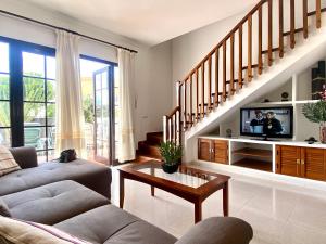 a living room with a couch and a tv at Casa Inma Las Piteras. Sol y agua in Costa Teguise