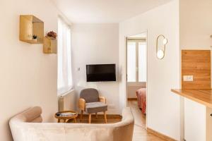 ein Wohnzimmer mit einem Sofa und einem Stuhl in der Unterkunft Maison tourangelle chic & cosy avec cour in Tours