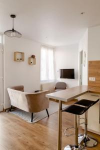 sala de estar con mesa de madera y sillas en Maison tourangelle chic & cosy avec cour en Tours