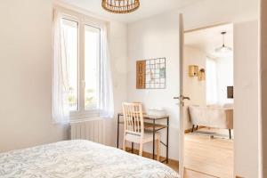 una camera con letto, scrivania e finestra di Maison tourangelle chic & cosy avec cour a Tours