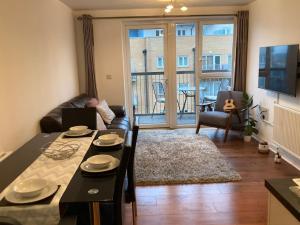 uma sala de estar com uma mesa e uma sala de estar com vista em Superb Apartment CR0 em Croydon