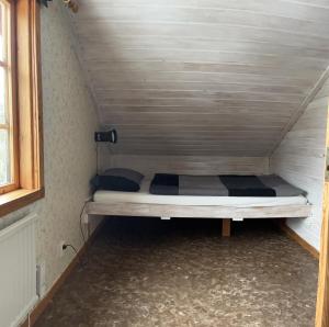 um pequeno quarto com uma cama na parede em Runeholm em Vimmerby