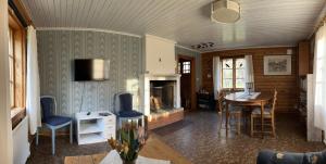 a living room with a fireplace and a table and chairs at Runeholm in Vimmerby