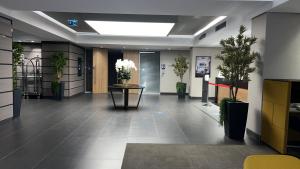 an office lobby with a table and potted plants at Antasya Residance-Fraser Place in Istanbul