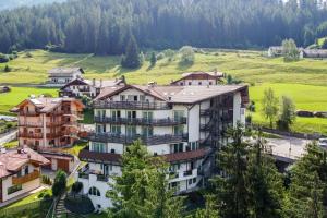 un edificio de apartamentos en un pueblo en las montañas en Hotel Fanes Suite & Spa, en Moena