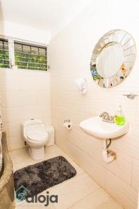 uma casa de banho com um WC, um lavatório e um espelho. em Villa Xtohil with private access to the magic 7 colors lagoon em Bacalar