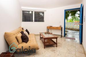 een woonkamer met een bank en een tafel bij Villa Xtohil with private access to the magic 7 colors lagoon in Bacalar
