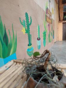 Mur z kaktusem namalowanym na boku w obiekcie Cabañas Maná w mieście San Juan La Laguna