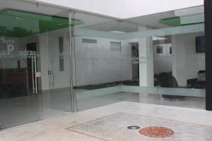 a glass shower in a room with a desk at Hotel Las Piedras San Jose in San José de Isnos