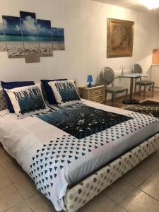 Cama grande en habitación con mesa y sillas en Monaco à 300m du Casino - Grand Studio avec Piscine, en Beausoleil