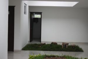 a white house with a garden in front of it at Hotel Las Piedras San Jose in San José de Isnos