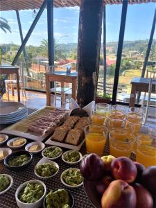 una mesa con comida y vasos de zumo de naranja en Lodge Los Bosques, en Matanzas