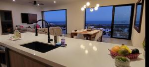 a kitchen with a counter with a view of a living room at Casa Sola Penthouse in Cabo San Lucas