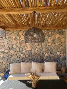 pared de piedra con sofá en una habitación en Casa el Ritón en Estancia Atamisque Tupungato en Tupungato