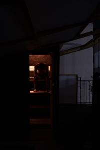 Ein Mann, der in einem dunklen Zimmer auf einem Bett sitzt. in der Unterkunft AET & o3 HOTEL in Tokio