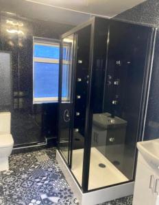 uma casa de banho com um chuveiro, um WC e um lavatório. em Sea Front Apartment With Massage Shower NETFLIX Great Location em Bridlington