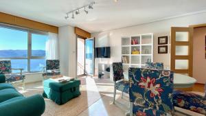 聖瑪爾塔德奧爾蒂蓋拉的住宿－The Cliffs - Ortigueira Kalmak，客厅配有蓝色的沙发和椅子