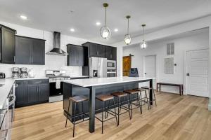 a kitchen with black cabinets and a kitchen island with stools at Modern Rustic in Branson