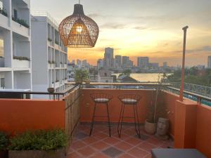 a balcony with two bar stools and a chandelier at Notre Maison 5 Saigon close Walking street in Thao Dien D2 in Ho Chi Minh City
