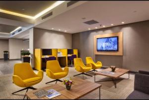 uma sala de espera com cadeiras amarelas e uma mesa em Antasya Residance-Fraser Place em Istambul