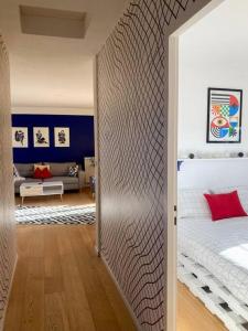 pasillo que conduce a un dormitorio con cama en Charmant Appartement Pop - Arty, en Thonon-les-Bains