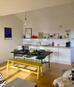 Il comprend un salon avec une table et une cuisine. dans l'établissement Charmant Appartement Pop - Arty, à Thonon-les-Bains