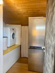a small kitchen with a refrigerator and a microwave at Charmant Appartement Pop - Arty in Thonon-les-Bains