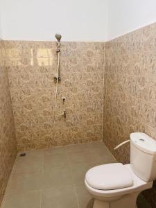 La salle de bains est pourvue d'une douche et de toilettes. dans l'établissement La Villa René, à Porto-Novo