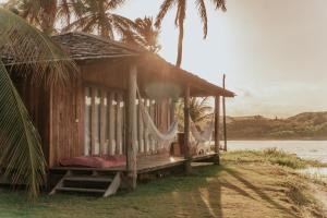 uma pequena cabana ao lado de uma massa de água em Casa na Lagoa em Paracuru