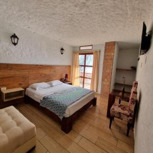 sypialnia z łóżkiem, krzesłem i oknem w obiekcie Alma Olon w mieście Olon