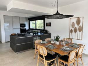 a kitchen with a wooden table and chairs in a kitchen at IsulaRossaBellaVista-GrandPenthouse in LʼÎle-Rousse