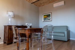 - une salle à manger avec une table, des chaises et un canapé dans l'établissement Alla Torre - nel cuore del Borgo storico, à Castagnole Lanze