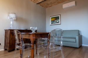 a dining room with a table and chairs and a couch at Alla Torre - nel cuore del Borgo storico in Castagnole Lanze