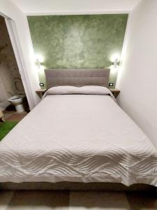 een slaapkamer met een wit bed en 2 nachtkastjes bij Mi casa es tu casa in Napels