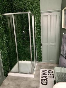 a bathroom with a shower with a green wall at Chic Townhouse near Tunnels Beaches Ilfracombe in Ilfracombe