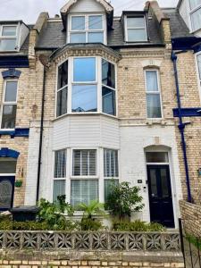 a large brick house with a large window at Chic Townhouse near Tunnels Beaches Ilfracombe in Ilfracombe