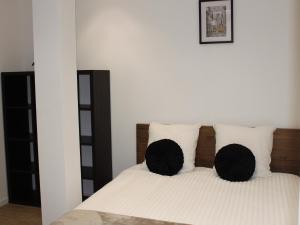 a bedroom with a bed with black and white pillows at Garnavie - Centre ville - Les Halles in Lourdes