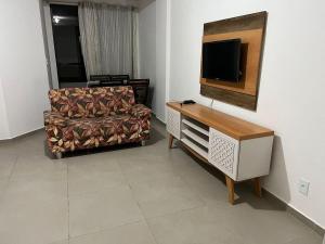 sala de estar con sofá y TV de pantalla plana en Apartamento com piscina 15 mim da Praia, en Cabo Frío