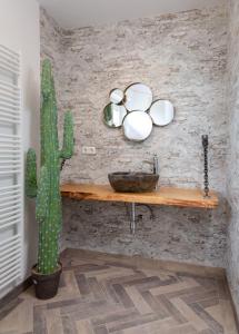 La salle de bains est pourvue d'un cactus et d'un lavabo mural. dans l'établissement Die-Deichbude-1-Bude-6, à Büsum