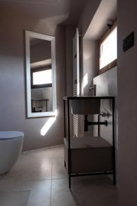a bathroom with a sink and a toilet and a mirror at Alla Torre - nel cuore del Borgo storico in Castagnole Lanze