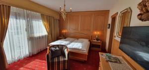 a bedroom with a bed and a flat screen tv at Villa Martha Vintage Hotel-B&B in Santa Cristina in Val Gardena
