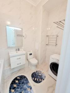 ein weißes Bad mit einem WC und einem Waschbecken in der Unterkunft Zaman in Atyrau