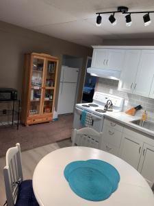 a kitchen with a table and a stove and a sink at Newly Renovated Basement Suite! in Lethbridge