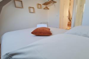 a pillow sitting on top of a white bed at Le Jaures 5 - T2 - Dernier Etage in Hennebont +2 photos
