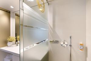 W łazience znajduje się prysznic ze szklanymi drzwiami. w obiekcie Sé Apartamentos - Sé INN Studios w mieście Braga