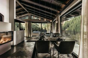 jadalnia ze stołem i kominkiem w obiekcie ONKL XONNA Premium Alpin Chalets w mieście Hüttschlag