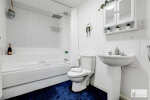 a white bathroom with a toilet and a sink at Spacious Whitwick Stay 3-Story House in Whitwick +18 photos