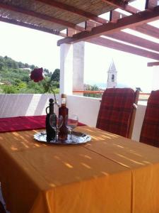 a table with a yellow table cloth and wine glasses at Apartment Luca in Prvić Luka